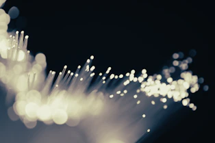 Modern fiber optic cables glowing with blue light in a sleek, minimalist office environment.