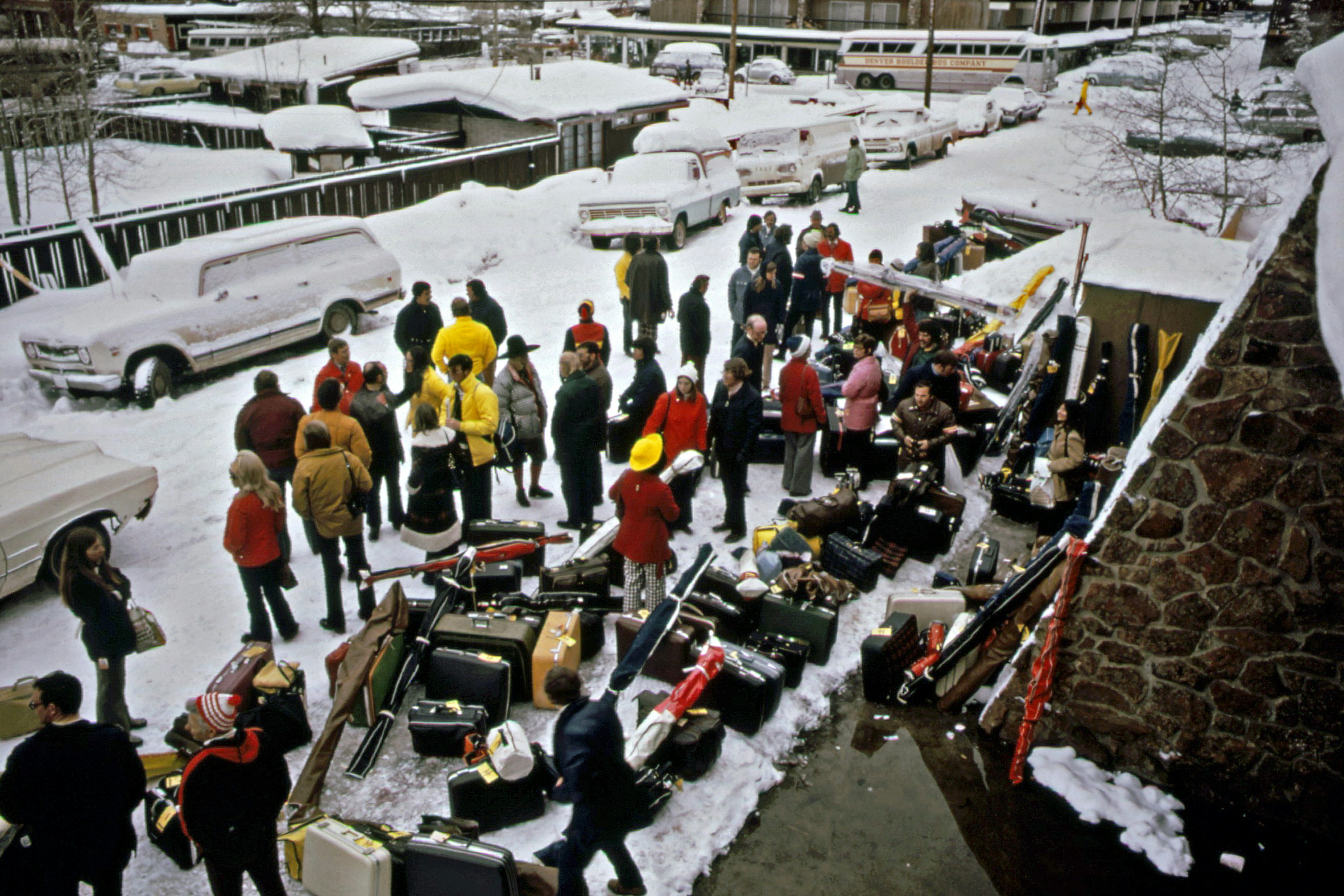 a group of people standing around a pile of luggage