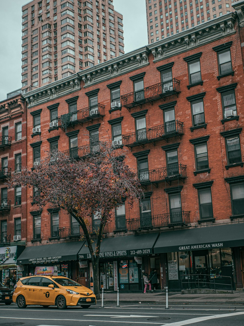 a yellow car parked in front of a tall building