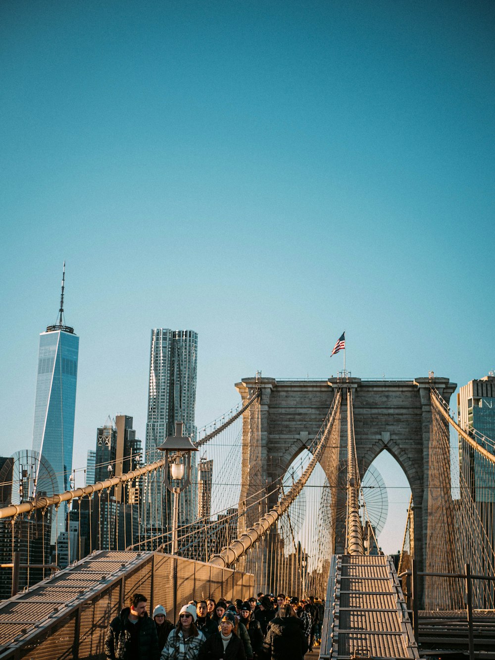 a group of people walking across a bridge