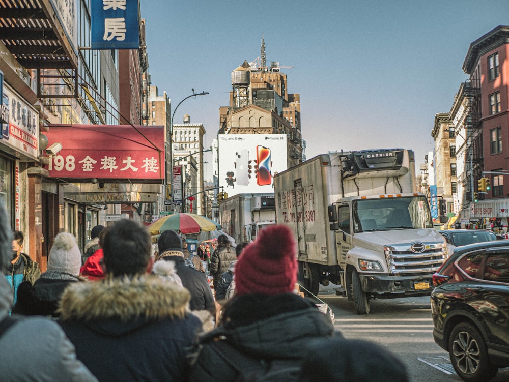 a group of people walking down a street next to tall buildings