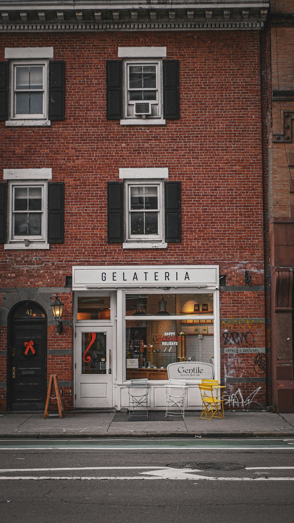 a red brick building with black shutters and windows