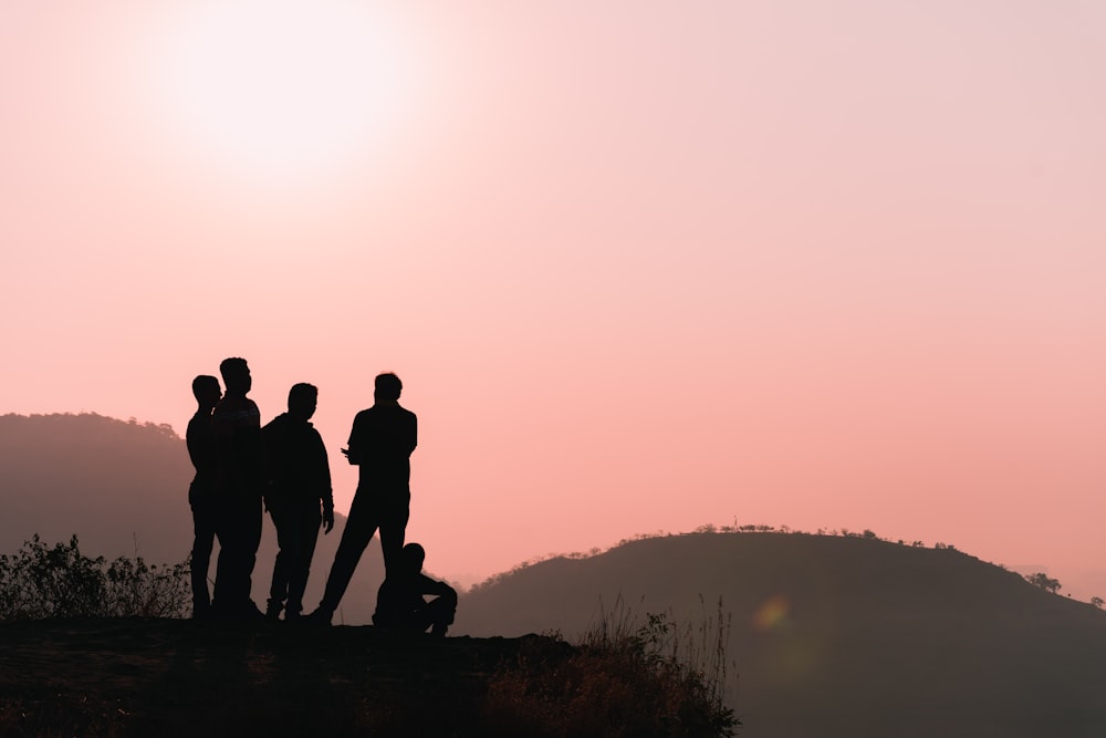 Un gruppo di persone in piedi sulla cima di una collina