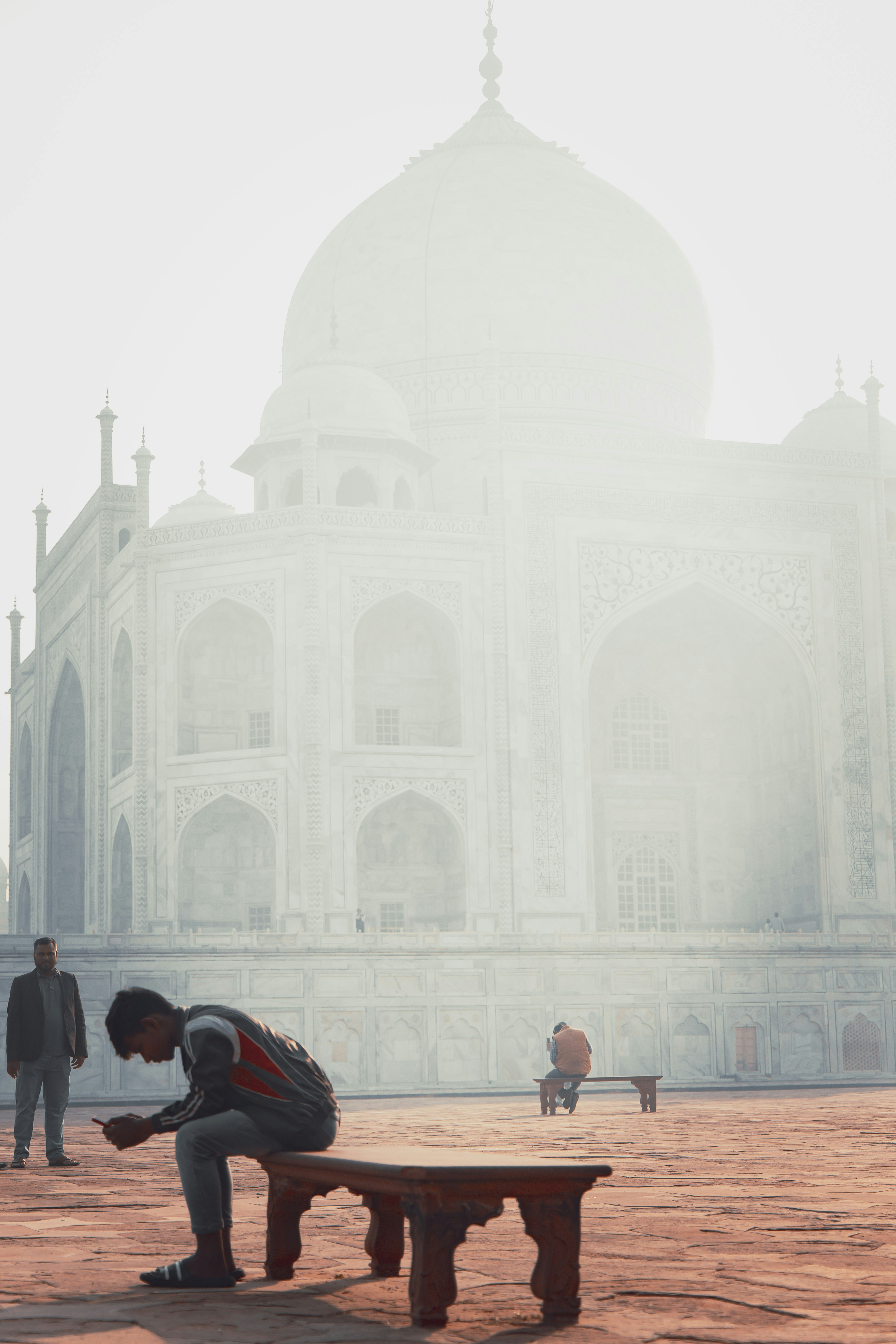 a man sitting on a bench in front of a building
