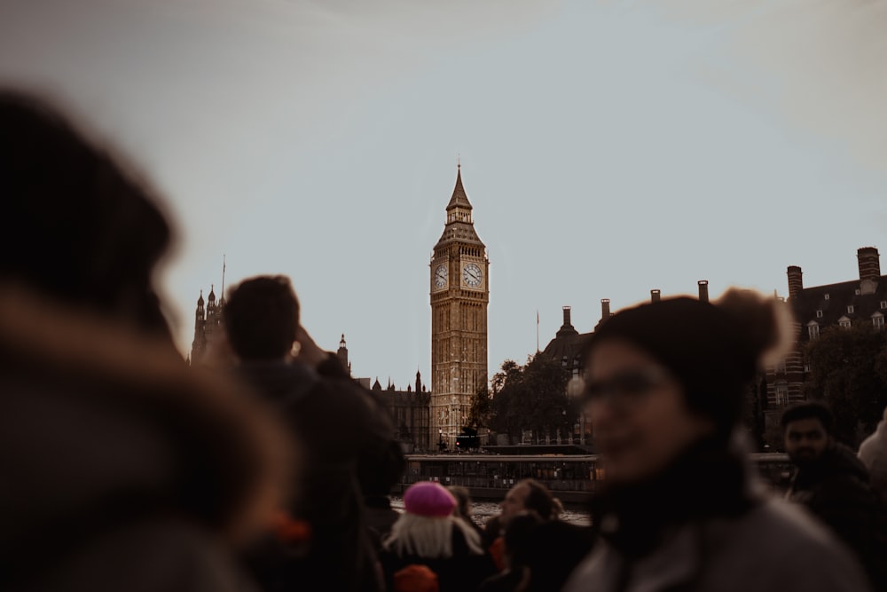 a group of people standing in front of a clock tower