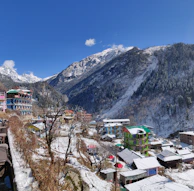 A peaceful mountain village blanketed in snow, with soft off-white and charcoal tones.