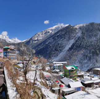 A peaceful mountain village blanketed in snow, with soft off-white and charcoal tones.