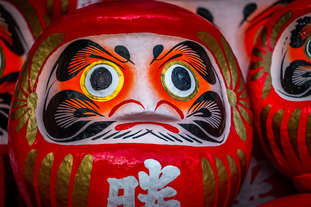 a close up of a red and gold mask