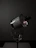 Elegant lifestyle shot of a perfume bottle beside a softly glowing candle in a dark room.