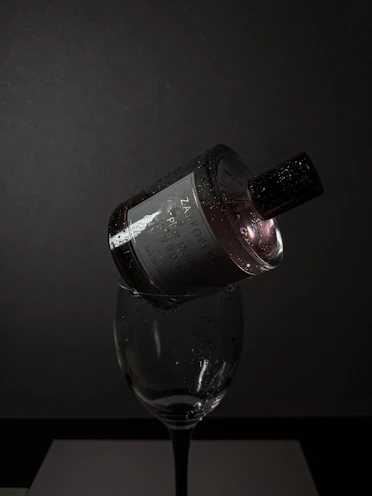 A moody evening scene with a dark perfume bottle glowing softly against a velvet backdrop.