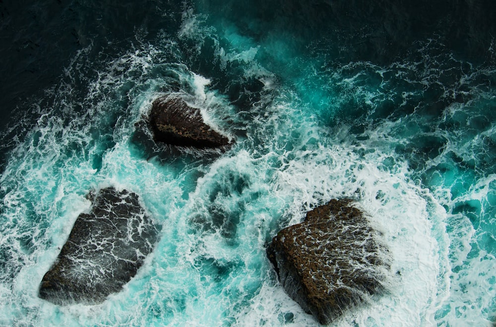 three rocks in the middle of a body of water