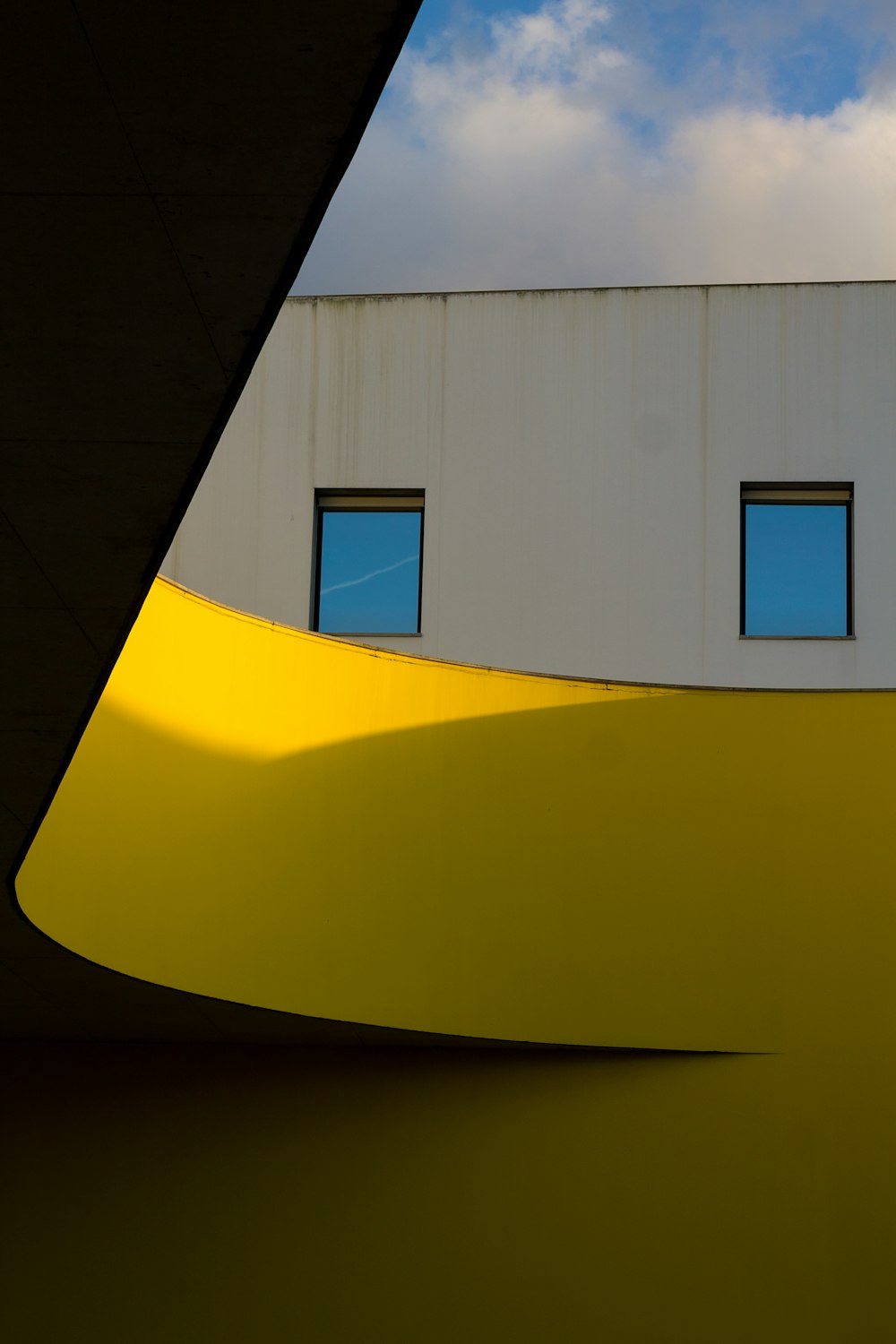 Un edificio con tres ventanas y un fondo de cielo