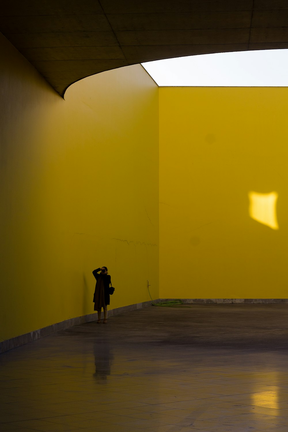 a person standing in a room with a yellow wall