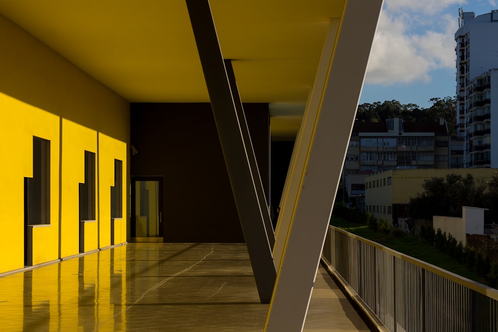a hallway with yellow walls and a metal railing