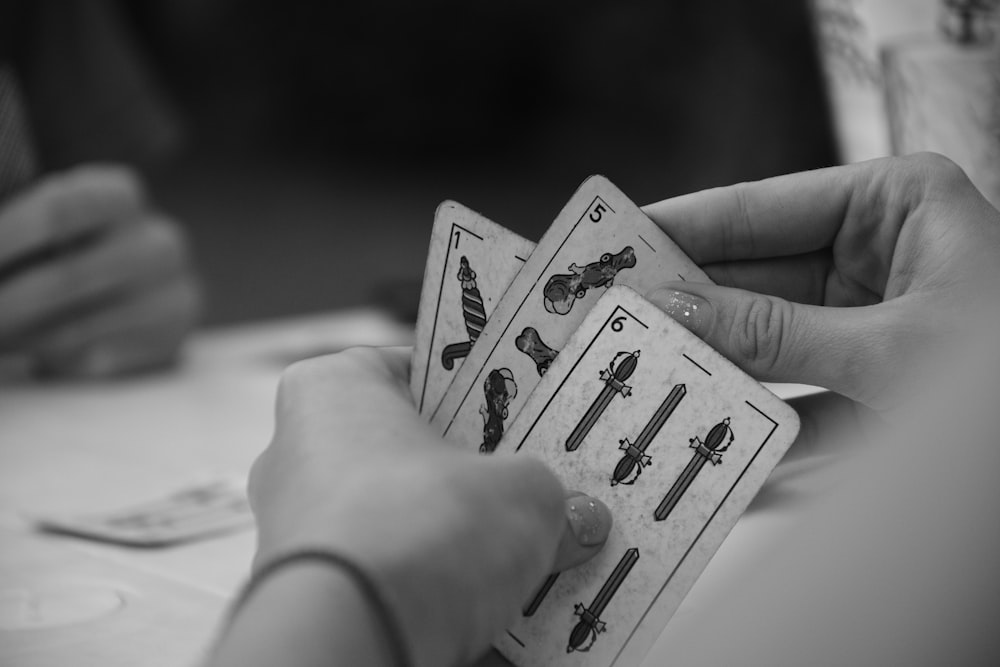 a person holding two cards in their hands