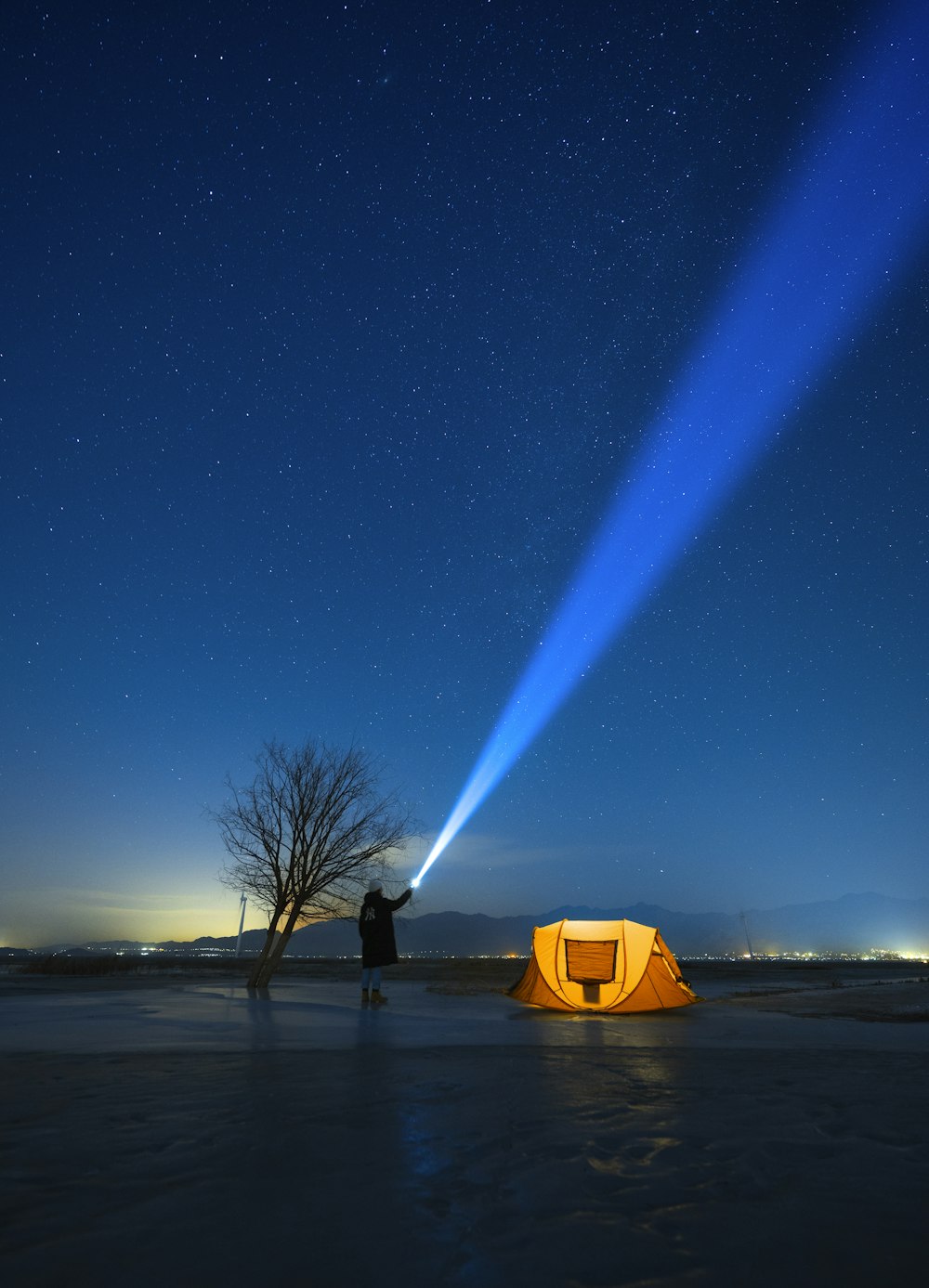 a person standing in front of a tent with a flashlight