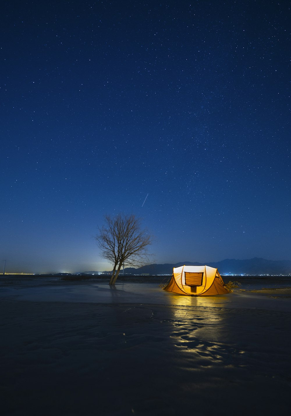 a tent set up on a beach at night