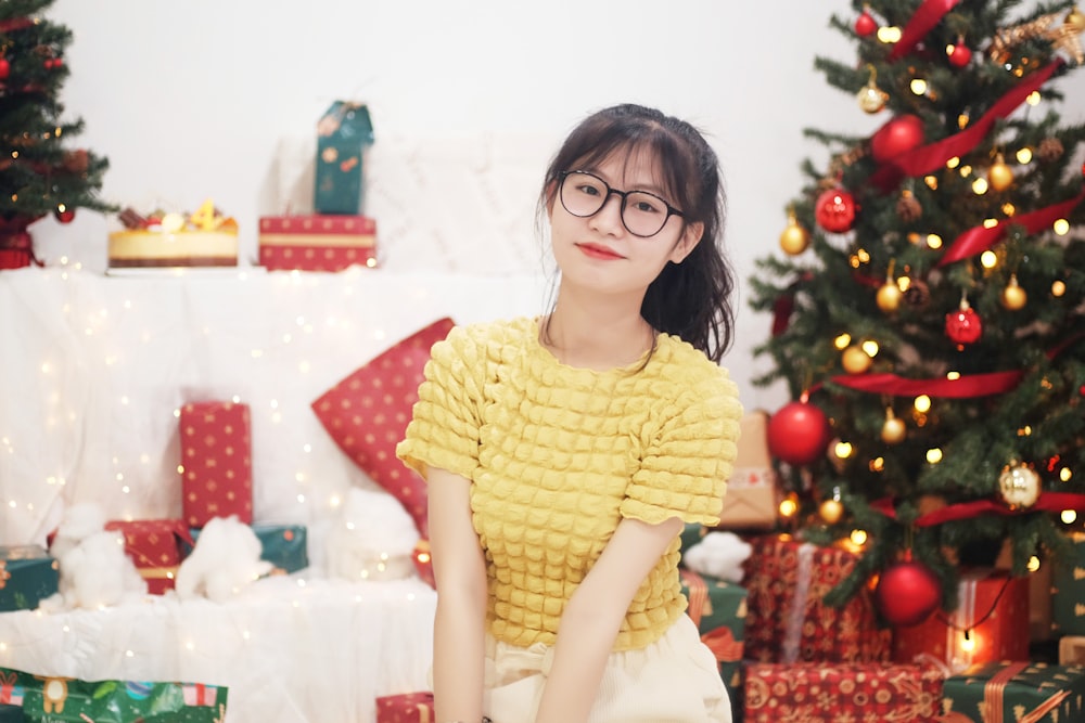 a woman sitting in front of a christmas tree