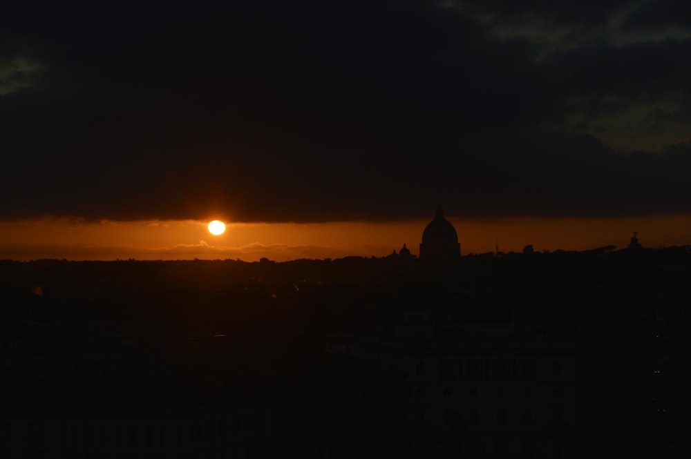 the sun is setting over a city skyline