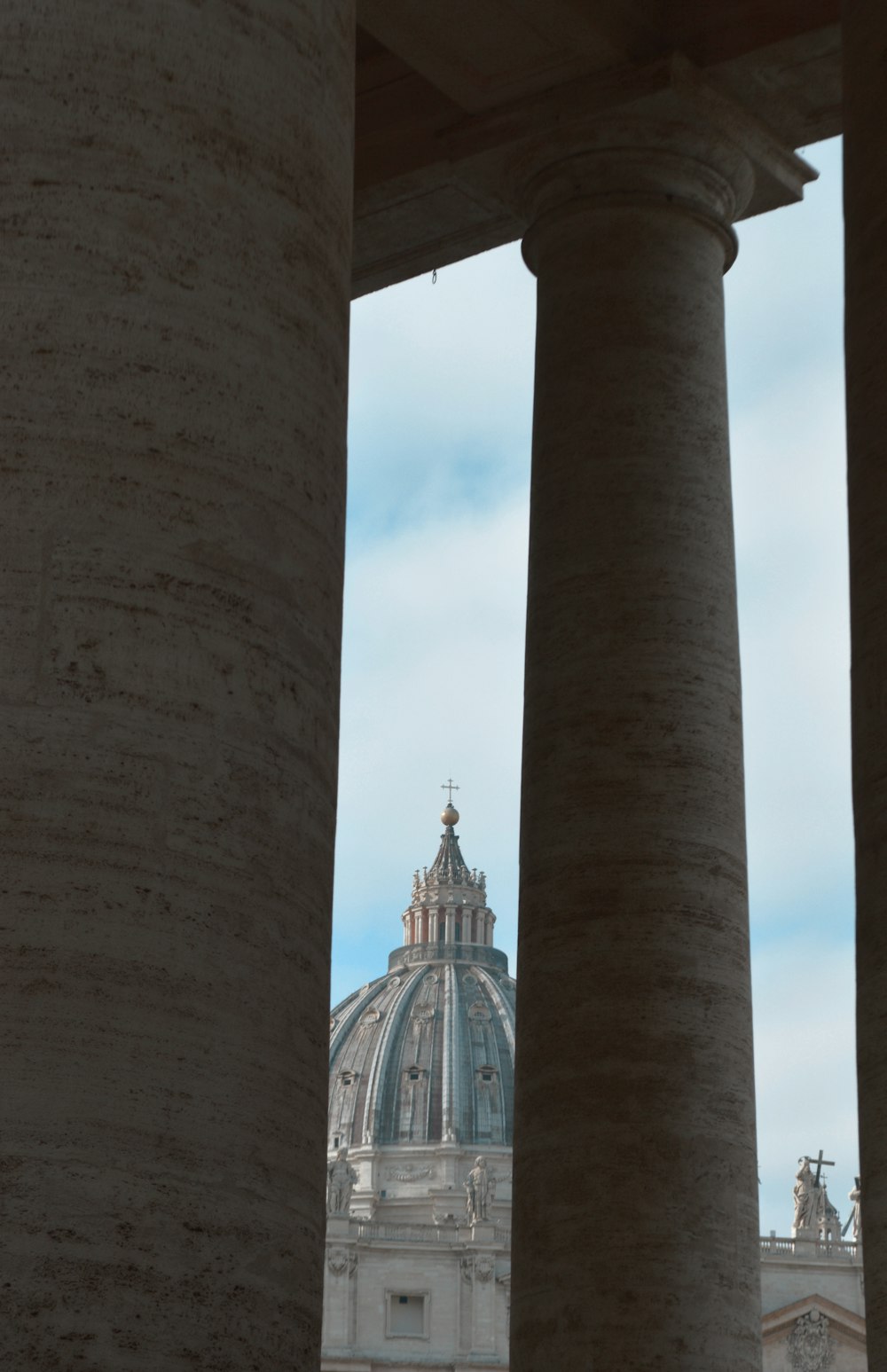 a view of a building through some pillars