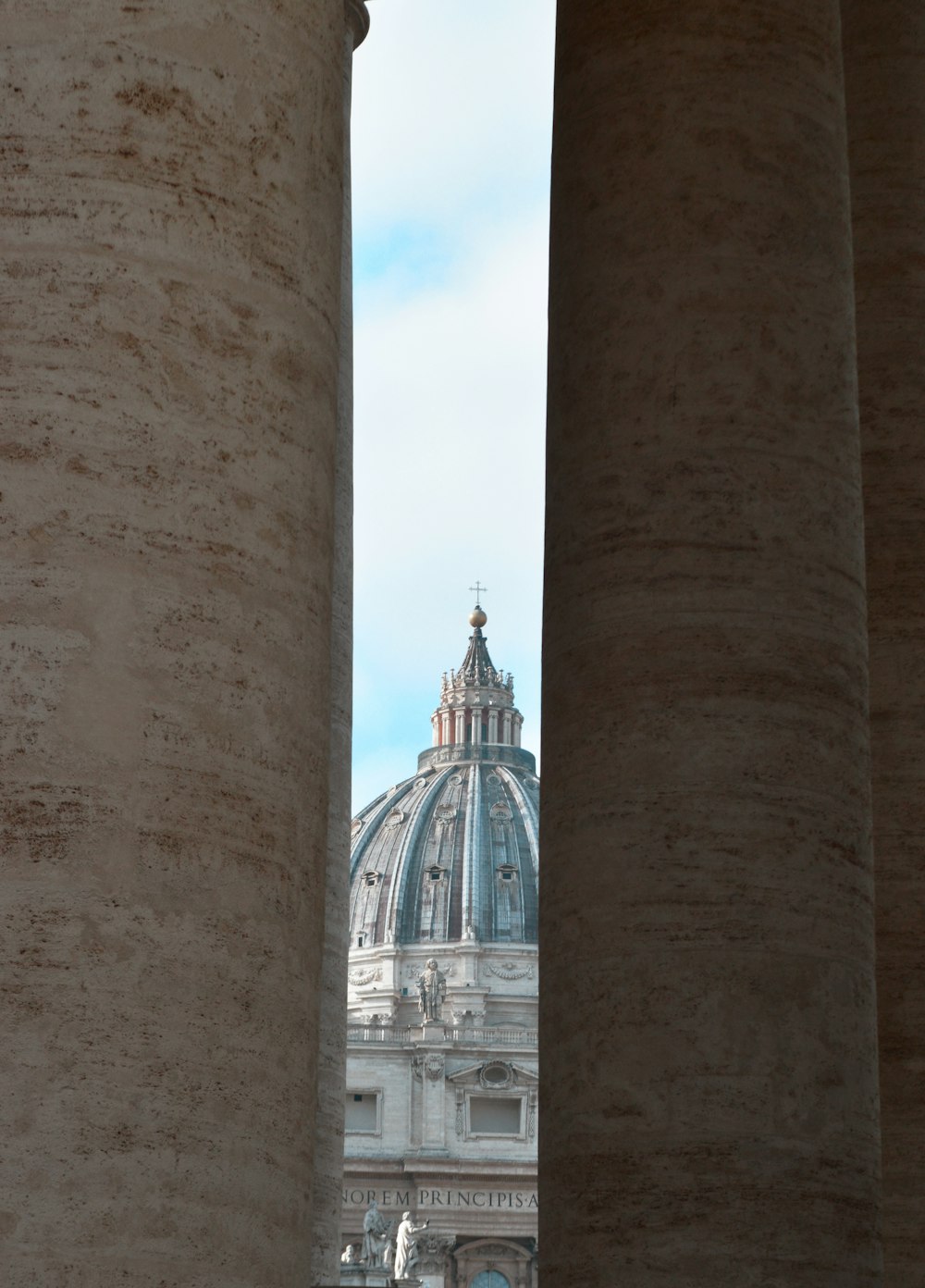 uma vista da cúpula de um edifício entre dois pilares