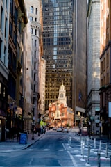 a city street with tall buildings and a clock tower