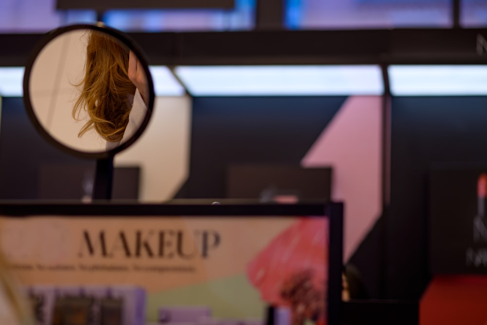 a woman's reflection in a round mirror