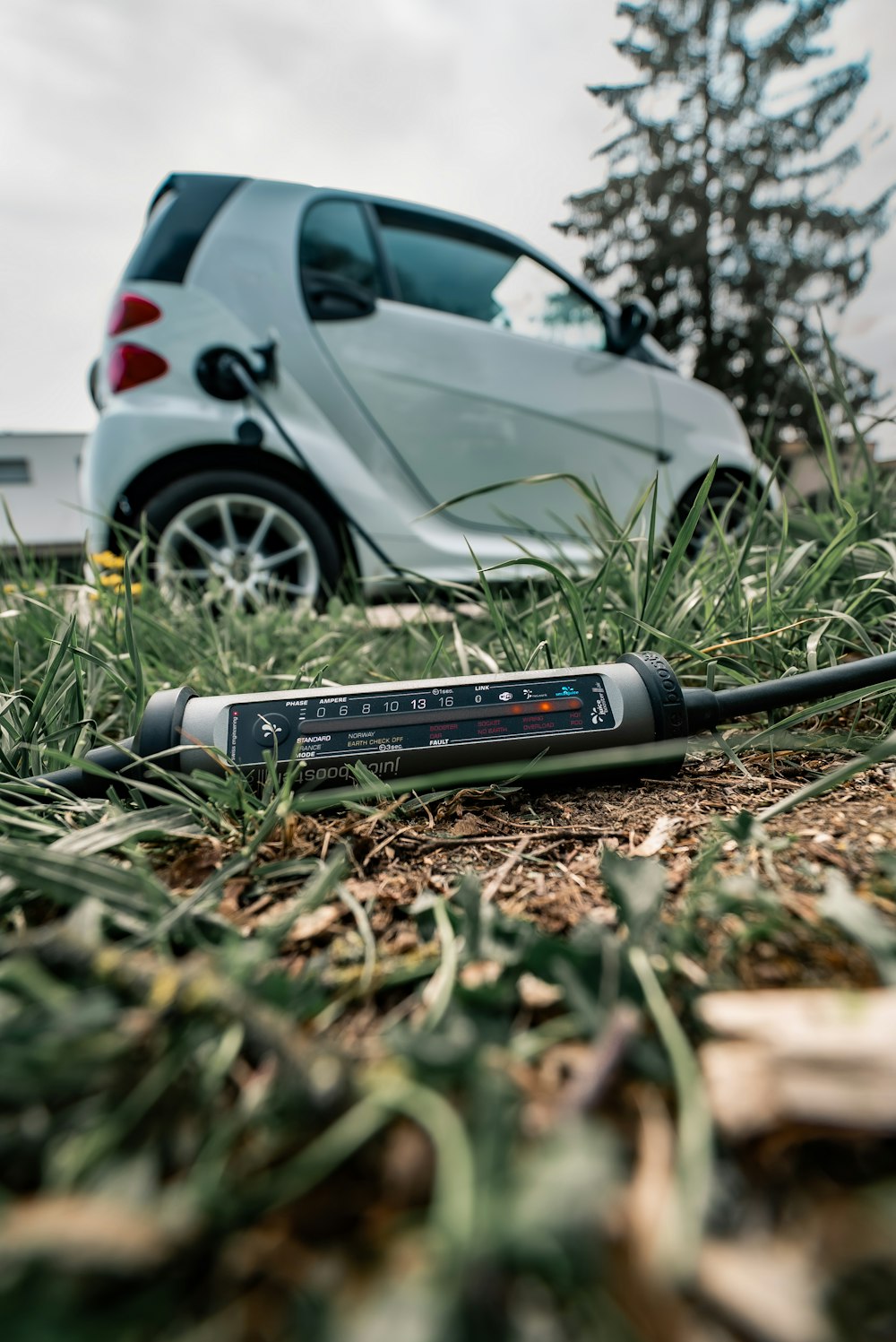 a car is parked in the grass next to a remote control