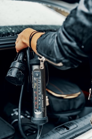 a person in a leather jacket is charging a car