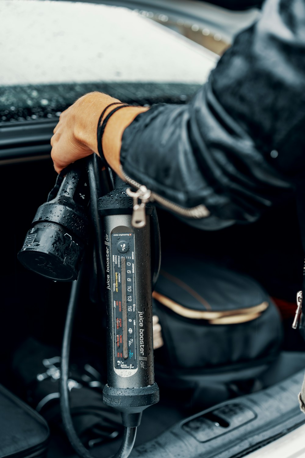 a person in a leather jacket is charging a car