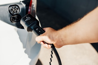 a person is plugging a car with a power cord