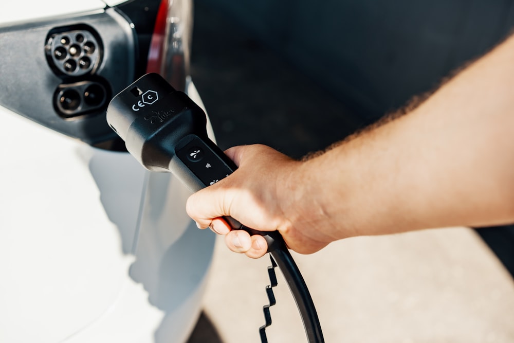 a person is plugging a car with a power cord