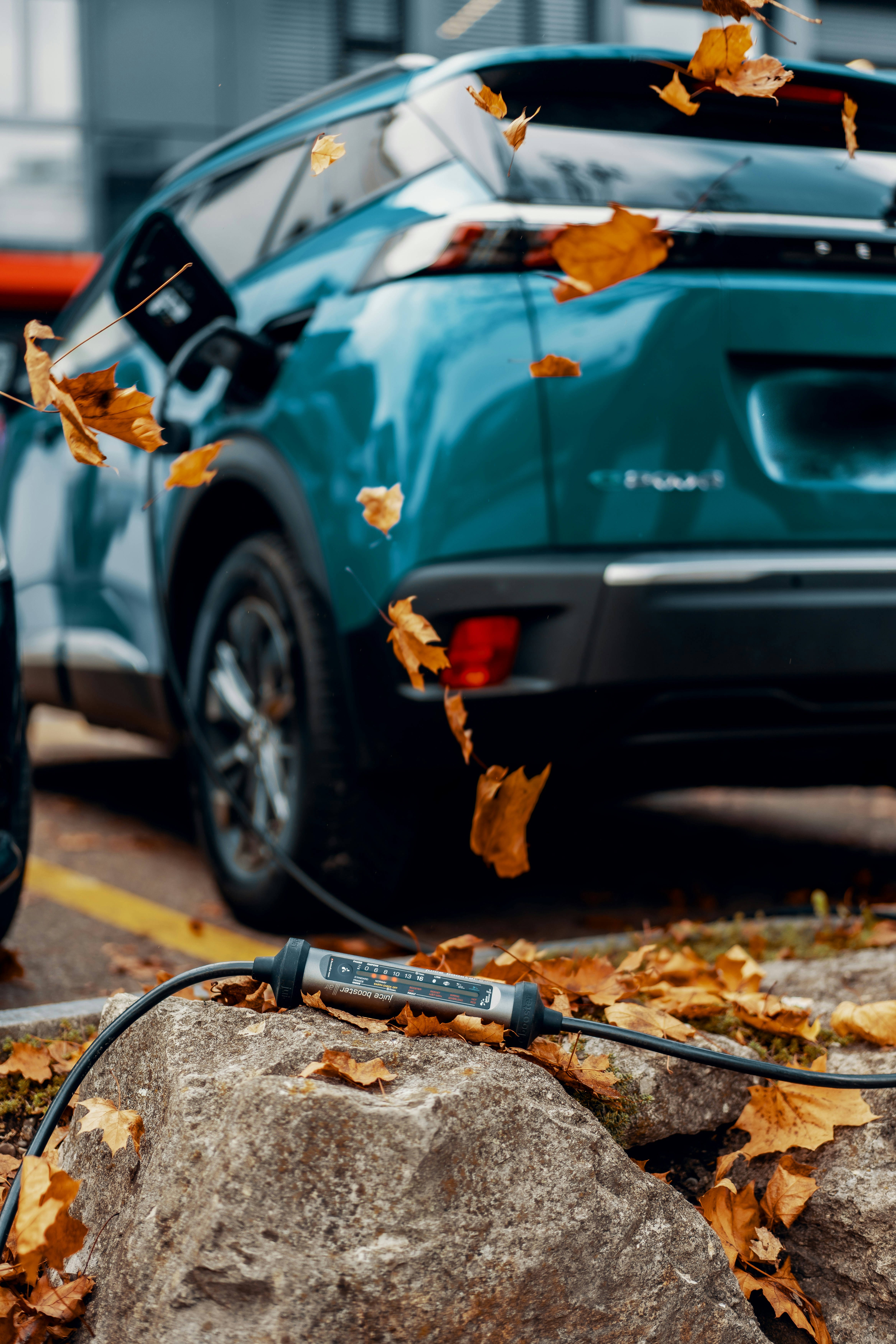 a blue car parked next to a pile of leaves