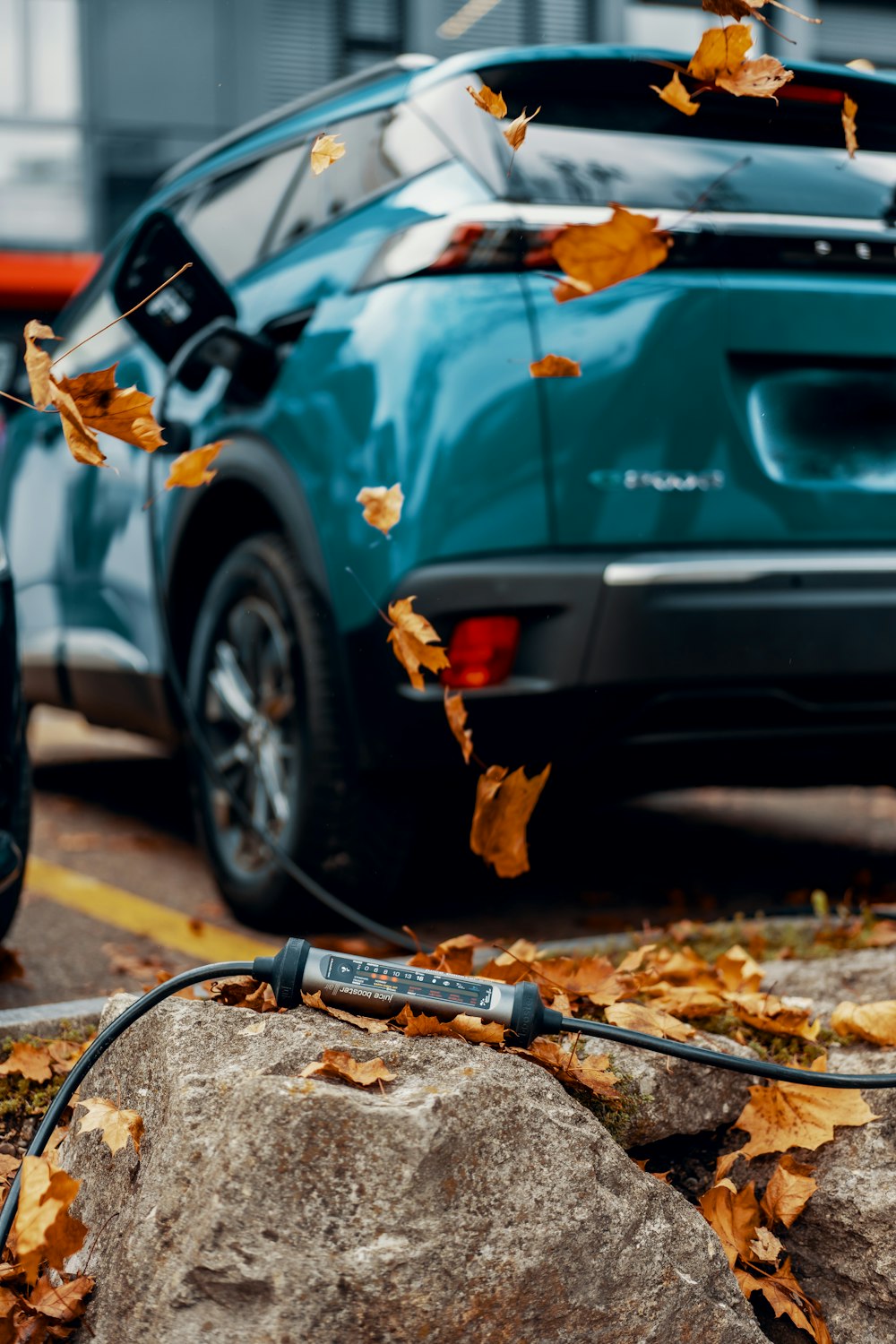 a blue car parked next to a pile of leaves