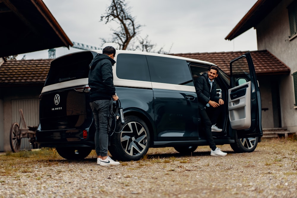 a couple of men standing next to a van