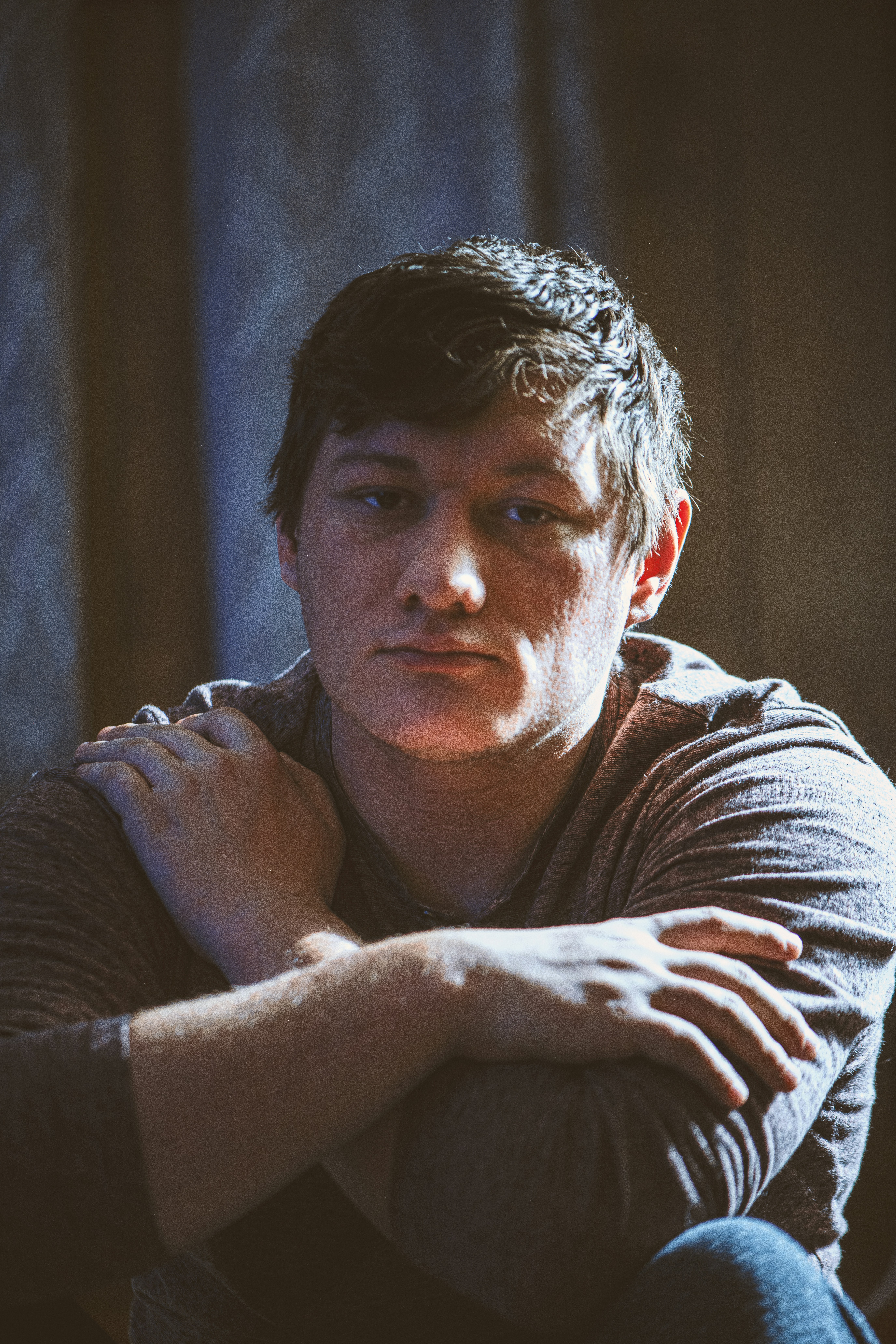 a young man sitting with his arms crossed