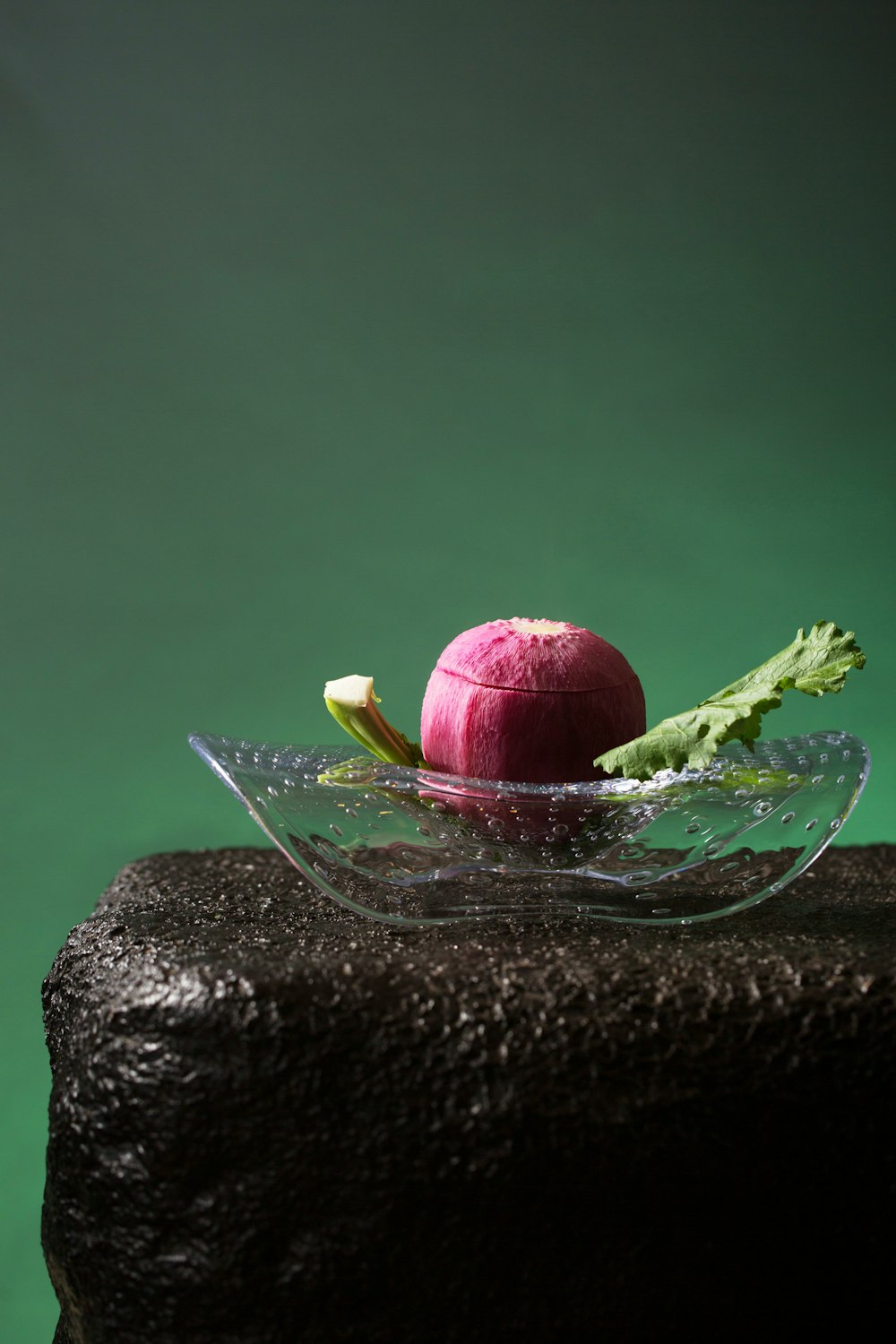 a glass bowl with a red apple inside of it