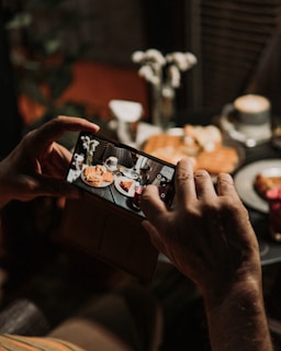 a person taking a picture of food on a table