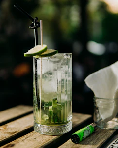 a glass of water with a lime slice and a straw
