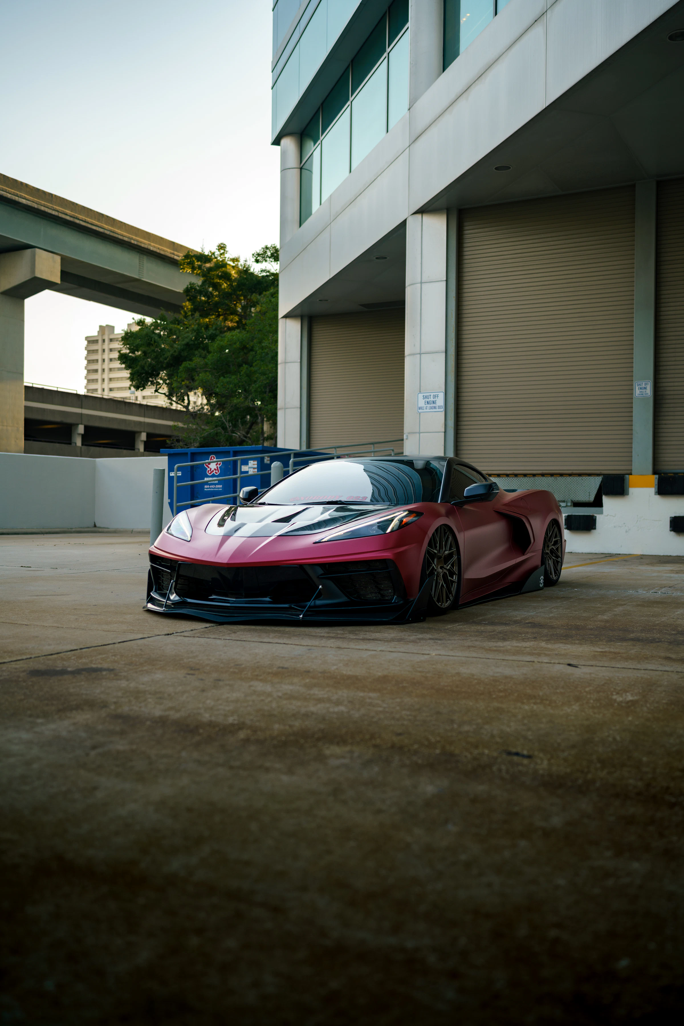 Sportive Chevrolet rouge devant un bâtiment moderne