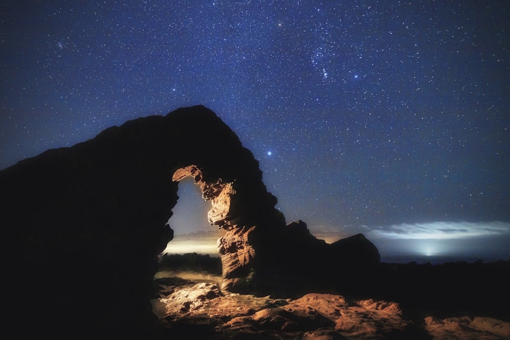 a rock formation with a star filled sky in the background