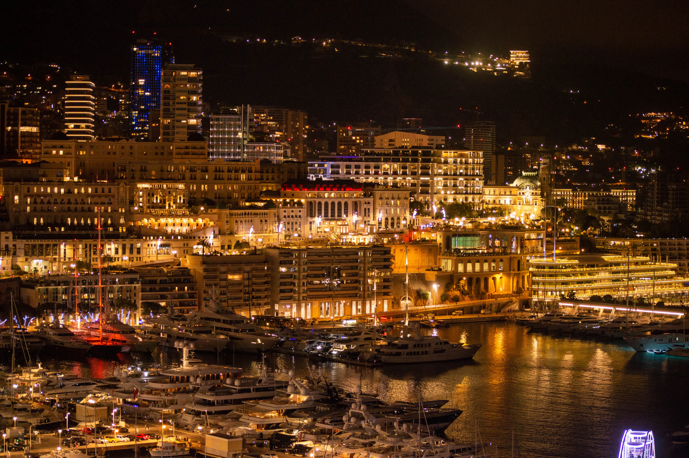 Monaco harbour at night, lit up and full of yachts