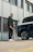 Portrait of a confident business professional standing in front of a fleet of electric vehicles charging.