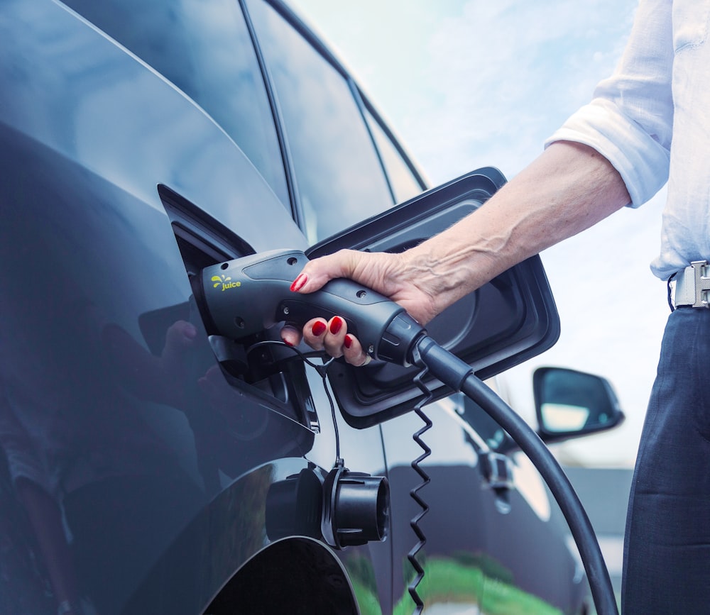 a person pumping gas into a car at a gas station