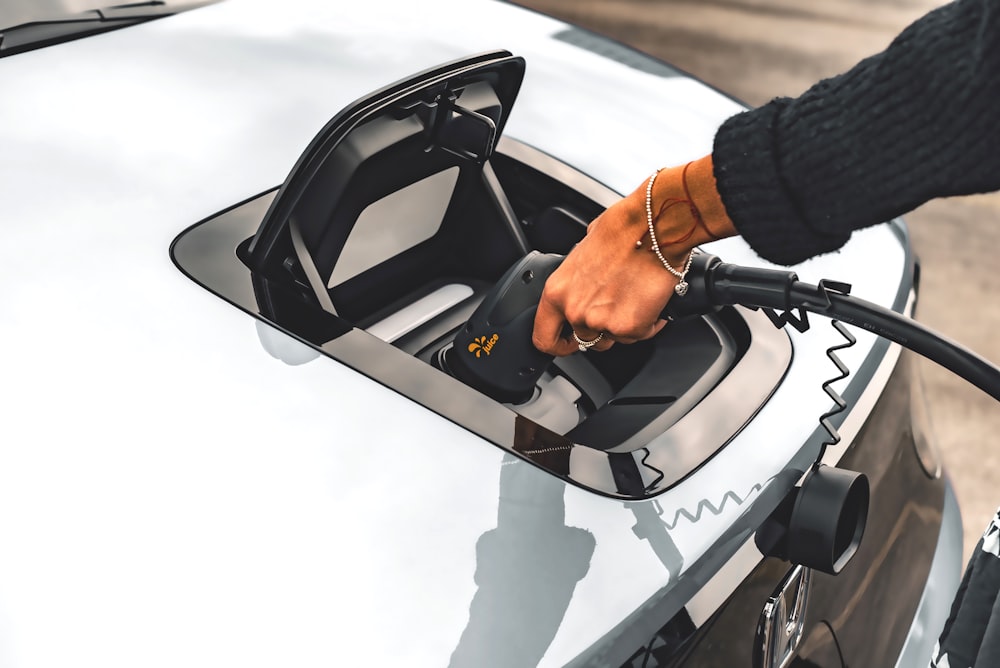 a person pumping gas into a car at a gas station