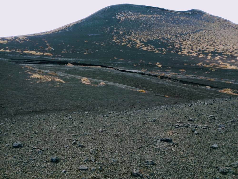 a mountain with a few rocks in the foreground