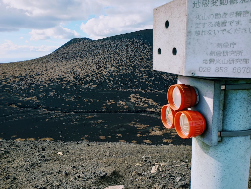 a sign on a pole in front of a mountain