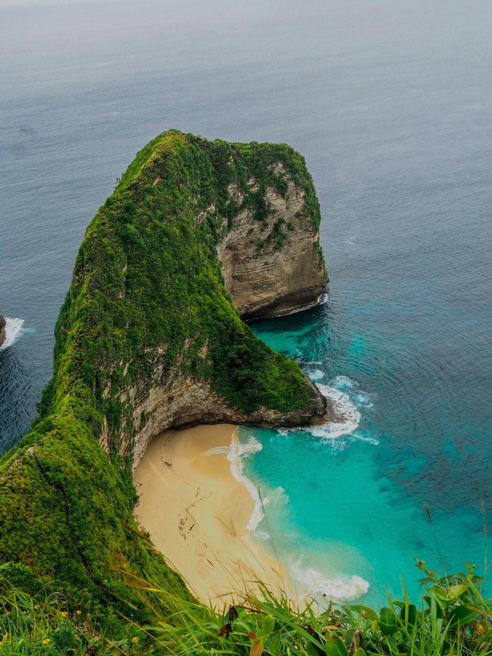 a boat is in the water near a large rock