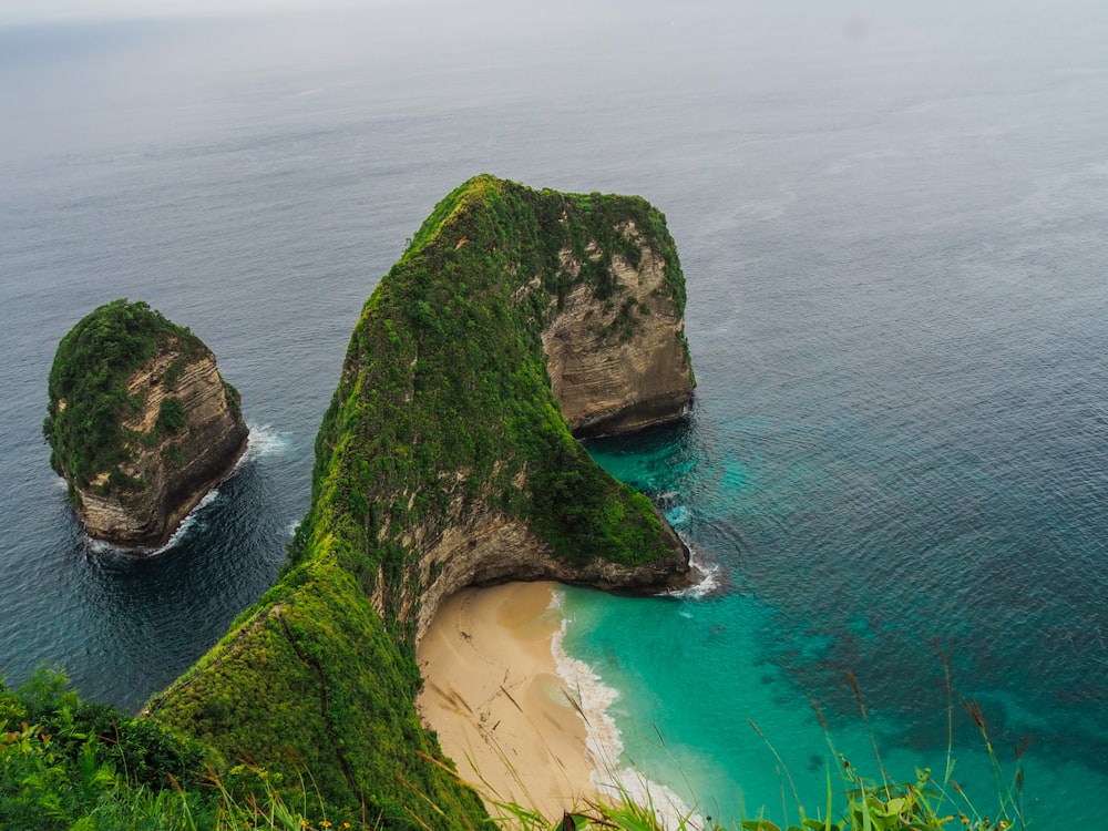 a couple of large rocks sitting on top of a lush green hillside