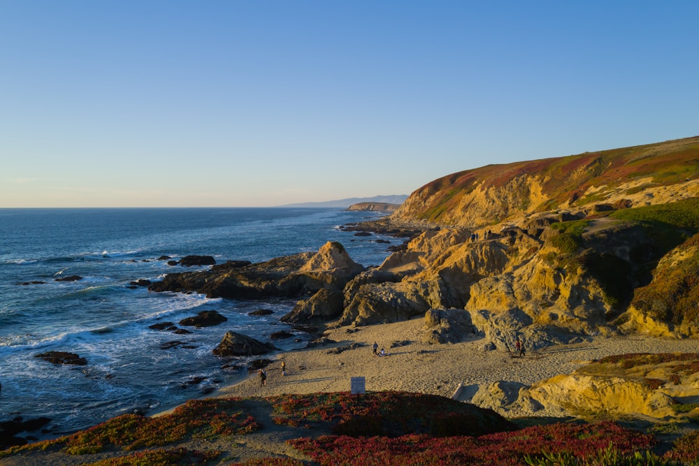 a view of a rocky beach with a body of water in the background